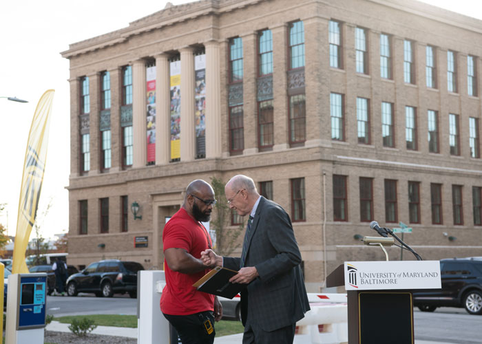 UMB President Bruce Jarrell (right) congratulates Tyrone Roper, director of the UMB Community Engagement Center, at the grand opening ceremony.