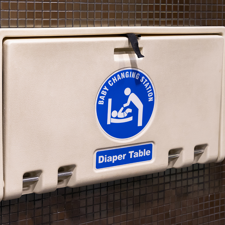 Baby changing table hanging on a restroom wall.