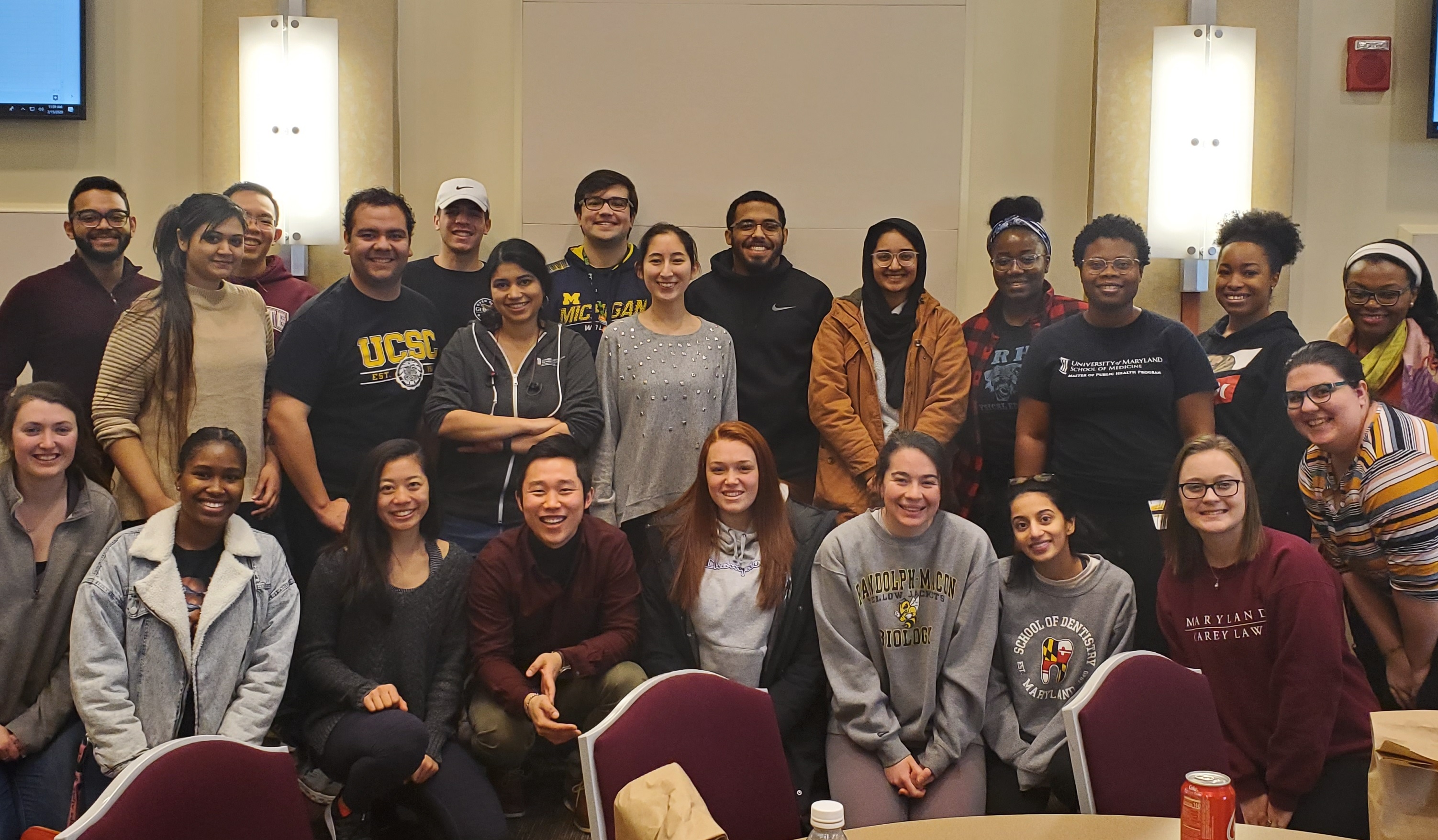 A group of smiling students in front of a white background.