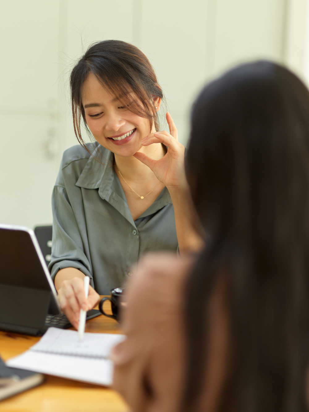 a consultant smiling at a student and pointing at their paper