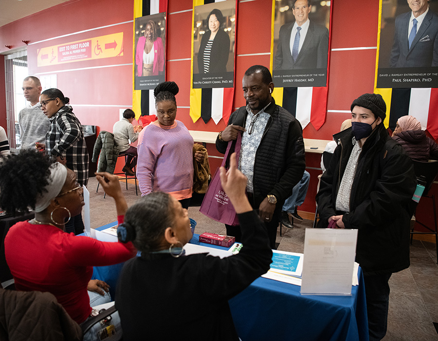 Attendees speak to people at a booth