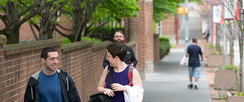 Photo of campus exterior with students walking.