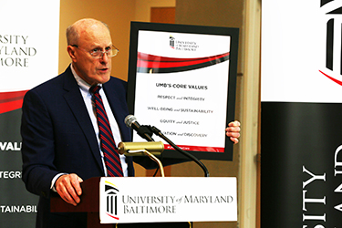 President Jarrell standing with a Core Values Poster