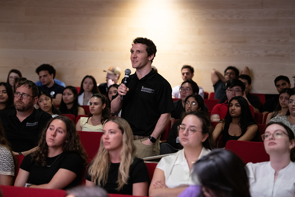 UMB Student asking question to panel at the 2026 IPE Day.