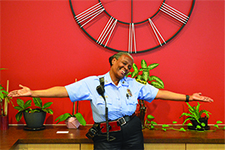 Portrait of Evelyn Greenhill in front of a red wall with an industrial clock