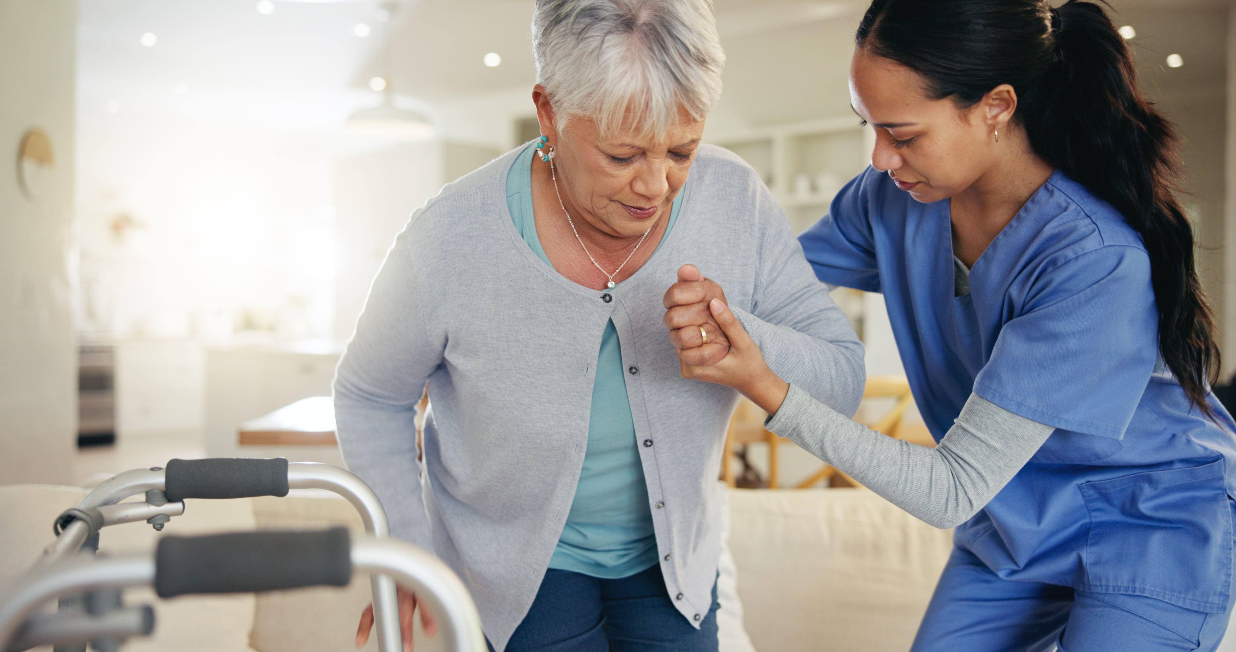 An elderly woman being assisted by a medical professional in her home.