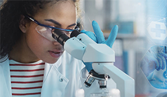 Researcher looking into a microscope