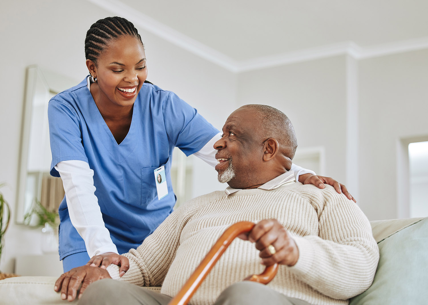 a uniformed caregiver talks with an elderly man