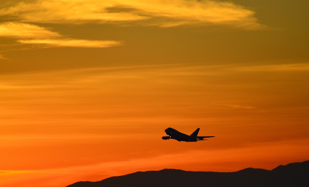 photo: silhouette of airplane flying in the sunset